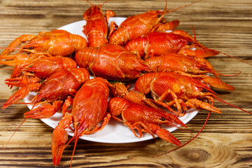 Boiled crayfish in plate on wooden table