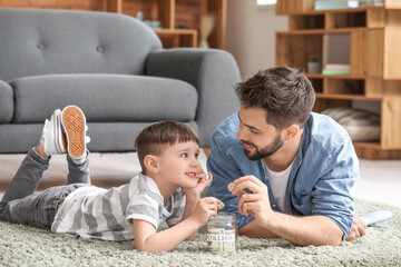Little boy and father with savings for education at home