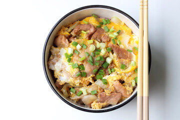 Close up  by top view ,Braised Pork Rice Served in a round bowl Placed on a white table with 1 pair of chopsticks and ready to eat
