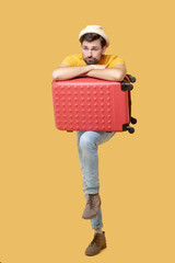 Sad bearded man in a hat with a suitcase