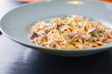 Traditional Italian pasta with cherry tomato, parmezan cheese and parsley served on white plate