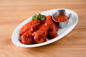 Buffalo chicken wings with hot tomato dip. Chicken meat in hot spicy sauce. Spicy food.