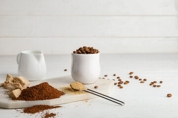 Composition with coffee powder, beans, sugar and milk on table