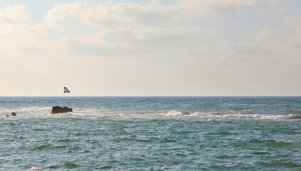 Israel flag attached to a cliff in the Mediterranean Sea