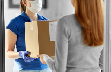 health protection, safety and pandemic concept - delivery woman in face protective mask and gloves giving parcel box to female customer at office