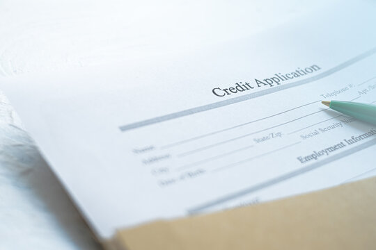 Close up of conceptual blank credit form drawn from letter and pen on desk.Credit Application - in a conceptual image
