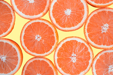 黄色の背景に並べたネーブルオレンジの断面