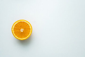 one orange fruit isolated on a white table. cut orange. view from above