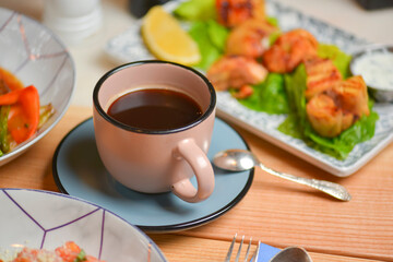 Cup of coffee. Salad with meat and vegetables. Italian cuisine, different dishes served in restaurant.