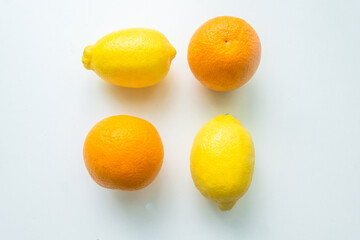 group of lemons and orange fruits isolated on a white table. view from above