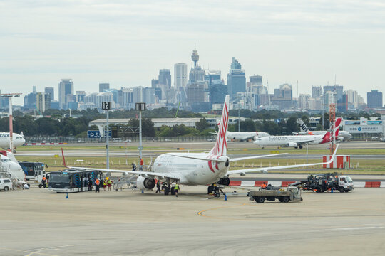 Sydney, Australia - Nov 1, 2017: View of passengers getting off an airplane at the Sydney Airport, with view of CBD in the background. It is the busiest airport in Australia.