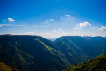 Natural view of the folded mountains and lush green valleys with clear sky and clouds of Cherrapunji, Meghalaya, North East India
