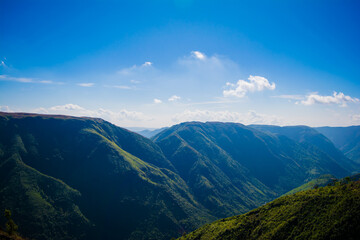Natural view of the folded mountains and lush green valleys with clear sky and clouds of Cherrapunji, Meghalaya, North East India

