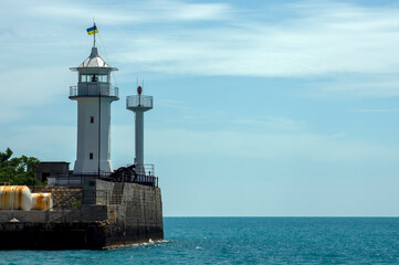 Fototapeta na wymiar Lighthouse and ancient fortifications, Yalta, Ukraine translation - Sberbank of Russia