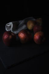 Fototapeta na wymiar group of red apples on slate plate with dark background in low key