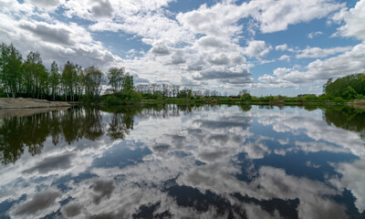 calm scene of beautiful sky with cumulus clouds reflection on the lake