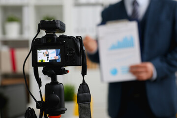 Male in suit and tie show stats graph pad making promo videoblog or photo session in office camcorder to tripod closeup. Vlogger selfie sale solution or finance advisor management information © H_Ko