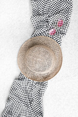Straw hat, sunglasses and polka dot scarf on concrete background.