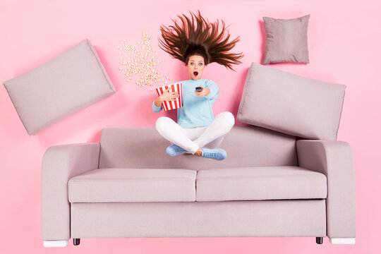Top view above high angle flat lay flatlay lie concept of her she nice attractive amazed girl sitting on divan lotus pose switching channel having fun isolated on pink pastel color background