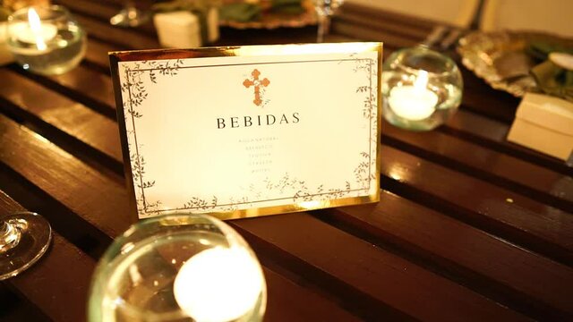 Menu card on the table lit with candle light, catholic drinks menu, close up trucking