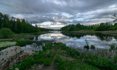 Fototapeta premium spring landscape with beautiful sky, clouds and tree reflections in the water
