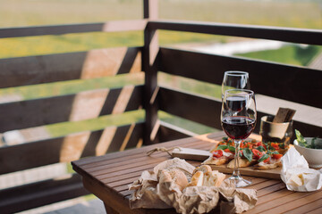 Glasses of red wine, delicious snacks. Outdoor dining with wine. Slow food concept.