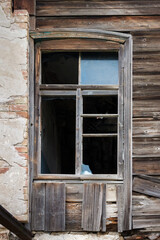 A window frame with broken glass in an old abandoned house