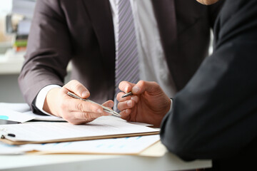Male arm in suit and tie fill form clipped pad with silver pen closeup. Sign gesture read pact sale...