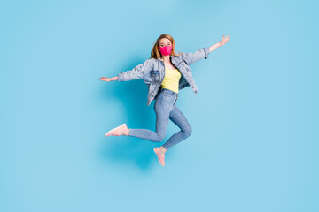 Fototapeta na wymiar Full length photo of pretty lady quarantine finished rejoicing outdoors outside jump high good mood spread arms fly wings wear face mask blazer jeans shoes isolated blue color background