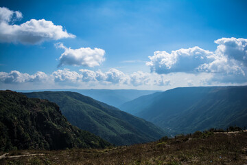 Natural view of the folded mountains and lush green valleys with clear sky and clouds of Cherrapunji, Meghalaya, North East India
