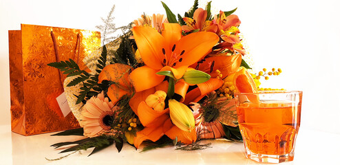 Cocktail Spritz with a bouquet of orange flowers and a gift bag. Isolated bouquet of flowers.
