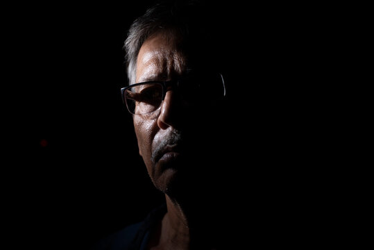 Portrait of a sad Indian Bengali man in light and shadow.
