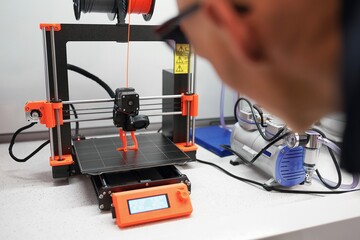 Man checking 3d printer with display, process of making things on 3d printer in laboratory - 354837934
