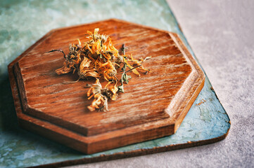 Dried dandelion flowers on a wooden tray. Blank for tea and medicinal drinks. Used to treat a myriad of physical ailments, including cancer, acne, liver disease and digestive disorders.