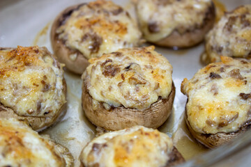 Stuffed mushrooms stuffed with cheese, mushroom stalks and onions. In a baking dish.