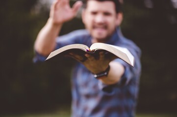 Young male speaking and holding the bible in his hands