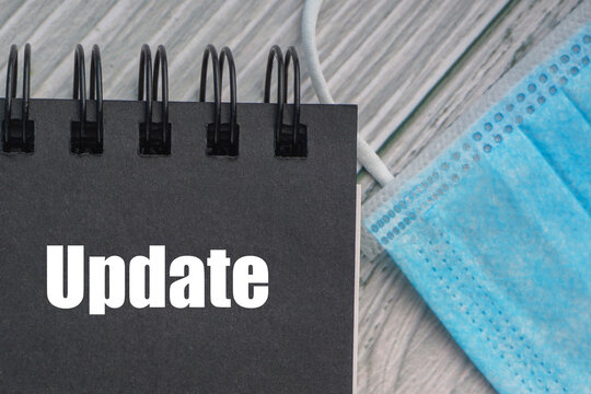UPDATE text with protection facemask on wooden background. Healthy and Coronavirus concept