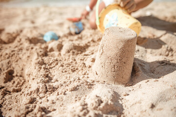Fototapeta na wymiar Family beach vacation concept, sand castle and family at sea