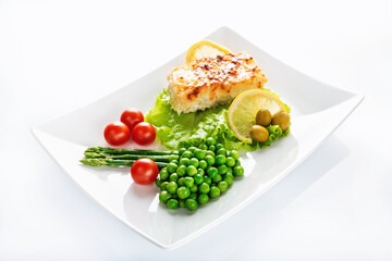 Cod fillet baked with cheese and onions with a garnish from an asparagus and green peas. On white background. High key. Selective focus.