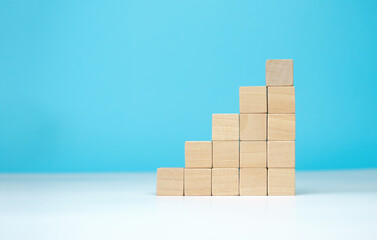 wooden blocks as a pyramid staircase on blue background. Success, growth, win, victory, development or top ranking concept