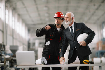  Colleagues working together. Arhitect and worker in factory.