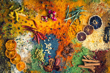 Many multi colored spices and dried fruits on the table
