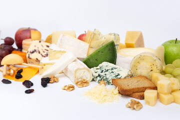 Different cheeses heap, fruits, nuts, bread for breakfast. Closeup shot, isolated objects on white background. Snacks for dinner or rustic cuisine concept