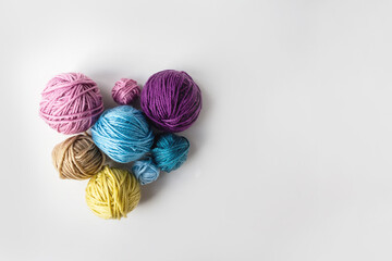 Multicolored Wool skeins in heart shape on light background. Copy space. Top view. Knitting as lovely hobby.