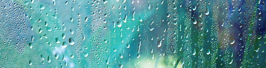 summer rain wet glass / abstract background landscape on a rainy day outside the window blurred background