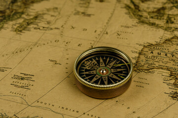 Fototapeta na wymiar Compass on old map of the world. Journey and discovery concept
