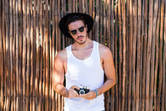 Hipster young man with vintage camera outdoors