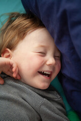 Little boy who has just woken from a sleep playing on his bed