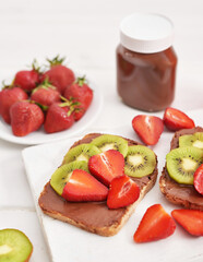 Fruit Sandwich, strawberries and kiwi. Peanut Butter Toast. Creative idea for kids breakfast, dessert or holiday meal, top view flat lay, healthy food for children. Good morning. Sweet breakfast