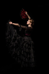 beautiful young dancer holding fan while dancing flamenco isolated on black